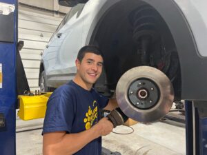Automotive technician standing next to a car on a list working on breaks | Braking System | Full Service Automotive Repair Center | Martinsburg WV
