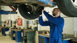 Car tech working on a lifted car brakes | Brake System Maintenance| Braking System Maintenance | Martinsburg Service Center, Martinsburg WV