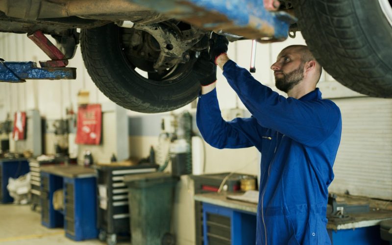 Car tech working on a lifted car brakes | Brake System Maintenance| Braking System Maintenance | Martinsburg Service Center, Martinsburg WV
