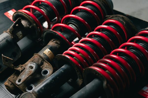 close up of red suspensions for vehicle - steering and suspension